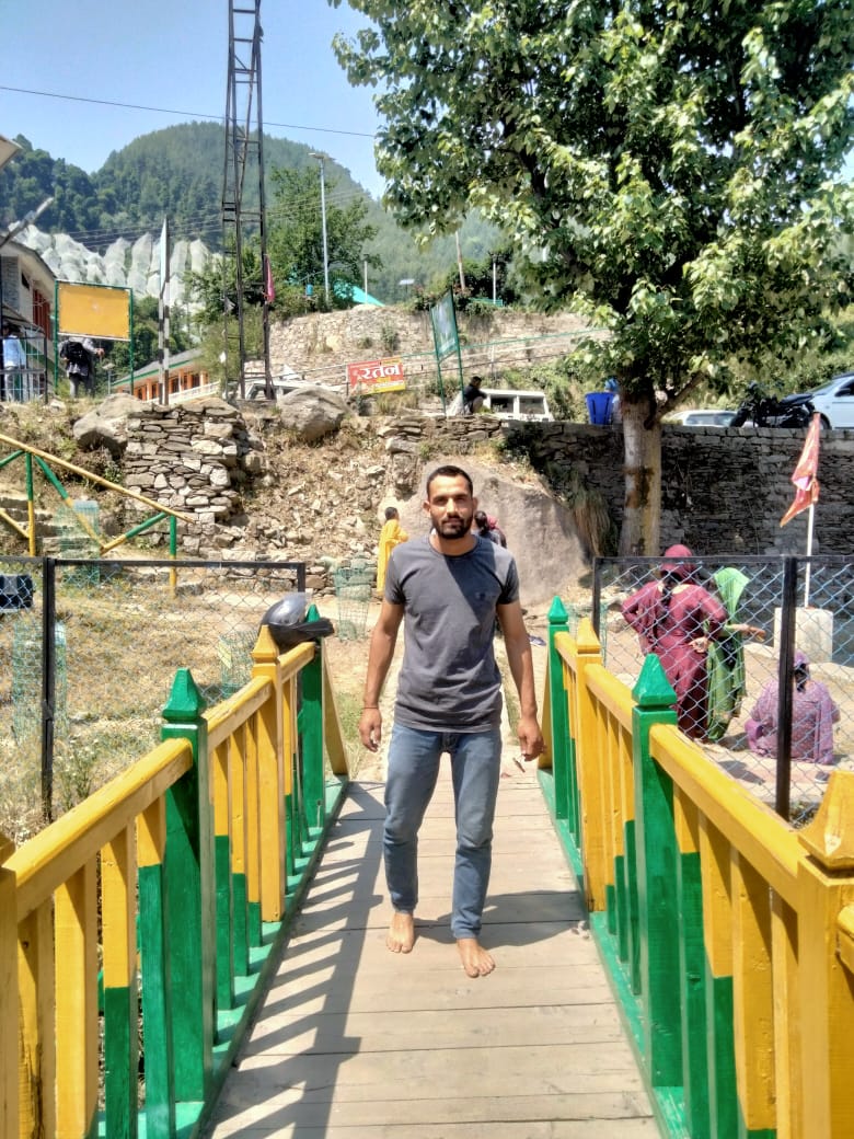 Discover Pandav Shila, the Janjheli Valley's Historical Gem 6 a person waling over a small bridge near pandav shila in janjehli 1723095761
